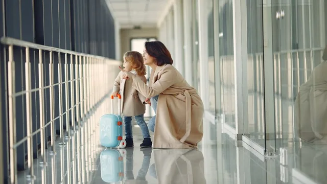 Mother and child with suitcases in an airport hallway