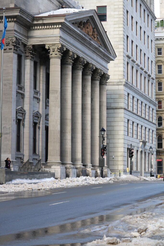 Historic bank building with columns in Montreal during winter.