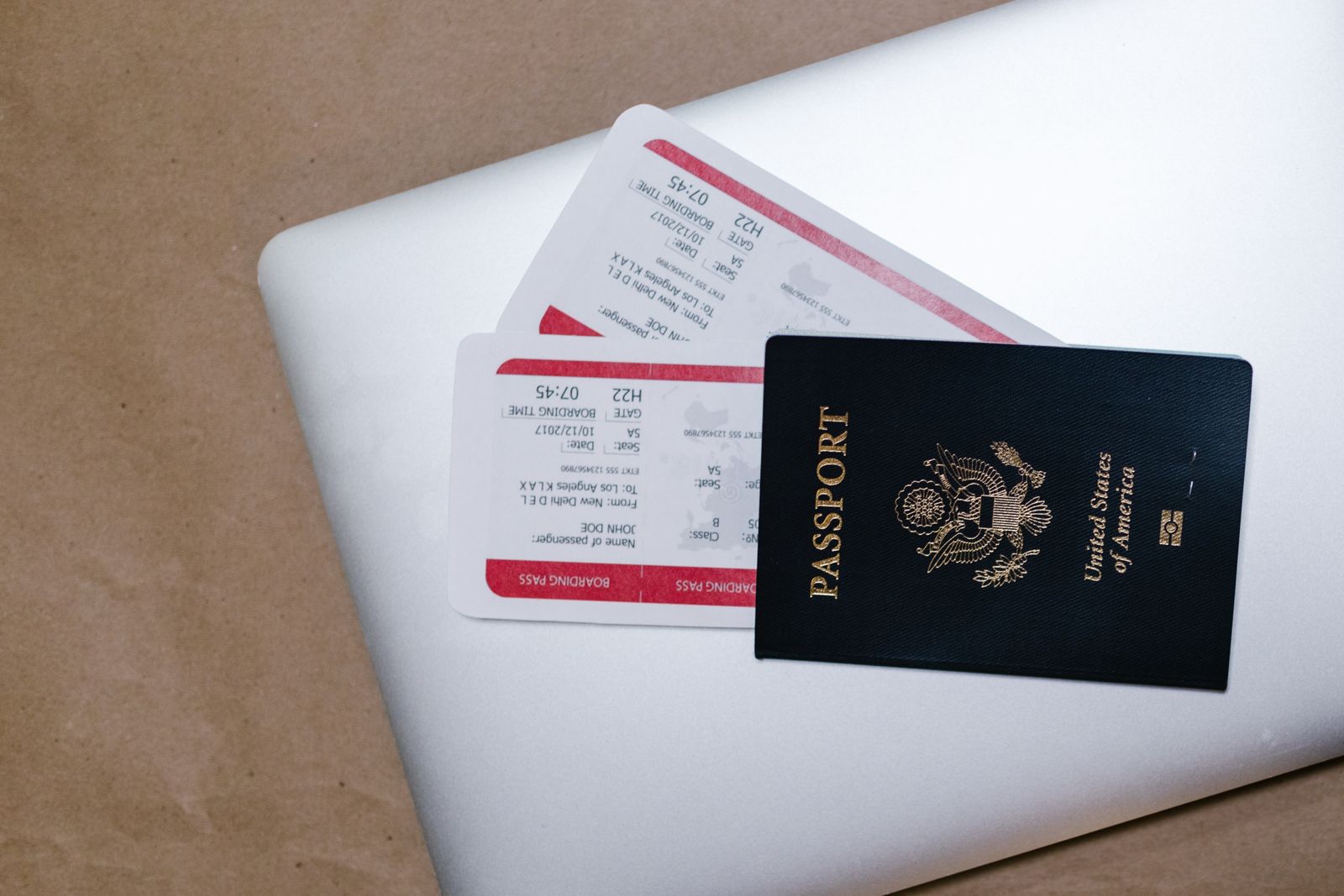 US passport and boarding passes resting on a laptop before a journey.